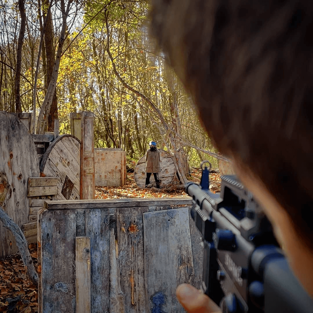 Vue immersive en pleine partie de paintball sur terrain boisé